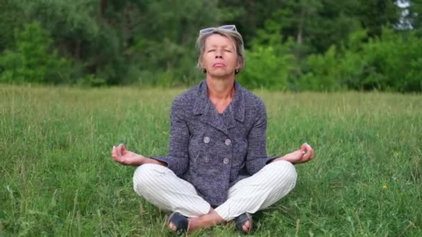 Mulher de negócios sênior atraente, relaxe no parque. Meditação. — Vídeo de Stock