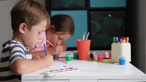 4 bin. Küçük tatlı beyaz kız ve oğlan evde birlikte resim çiziyorlar. — Stok video
