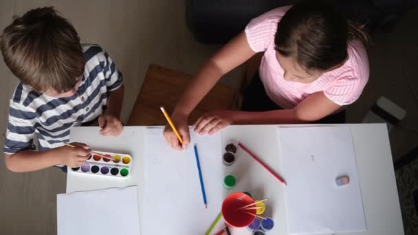 4k. μικρό χαριτωμένο καυκάσιο κορίτσι και αγόρι ζωγραφίζει μαζί στο σπίτι — Αρχείο Βίντεο