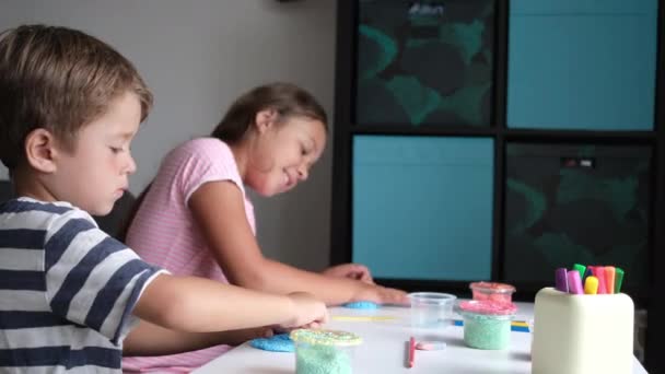 4 bin. Beyaz tenli küçük tatlı kız ve oğlan evde birlikte heykel yapıyorlar. — Stok video