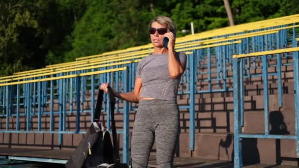 Femme âgée active aller à l'entraînement de fitness dans le stade de la ville — Video