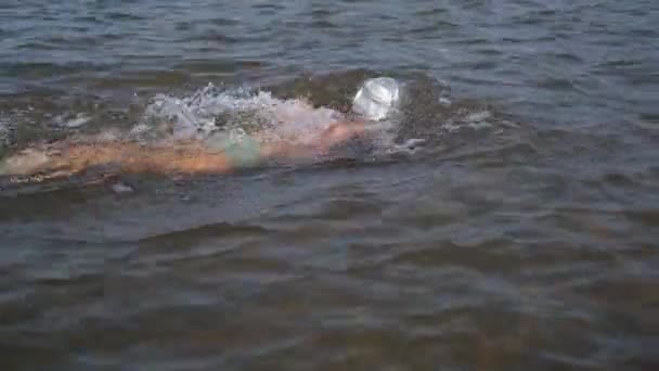 Pequeño niño nadar bajo el agua en gorra de natación — Vídeos de Stock