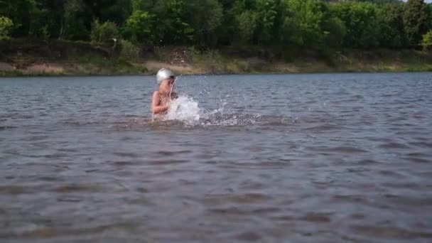 Niño pequeño nadar, jugar y salpicar el agua en la gorra de natación — Vídeo de stock