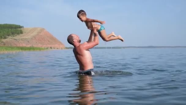 Father and son swim and play in the water — Stock Video