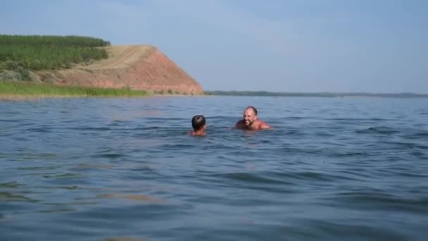 Otec a syn plavou a hrají si ve vodě — Stock video