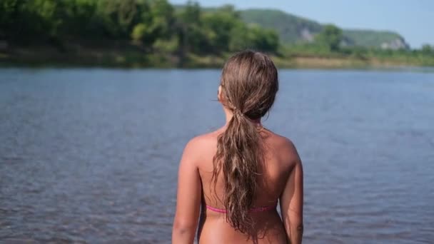 Zeldzaam uitzicht van weinig Kaukasisch meisje staan in het water. — Stockvideo