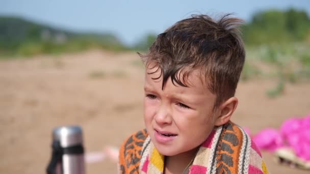 Niño pequeño después de nadar en el agua, sentarse en la playa — Vídeos de Stock