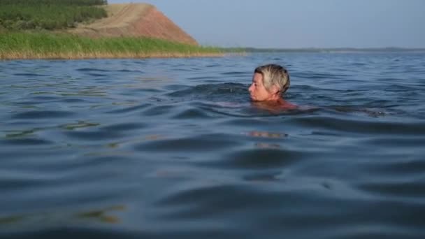 Active senior woman in swim suit swim in the water — Stock Video