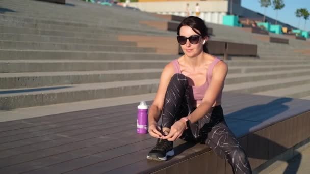 Joven mujer fitness prepararse para correr, sentarse y escuchar música — Vídeos de Stock