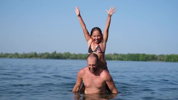 Fröhlich fröhliches Mädchen spielt mit Vater im Wasser — Stockvideo