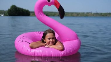 Neşeli mutlu kız oynuyor ve suya flamingo sıçrıyor.