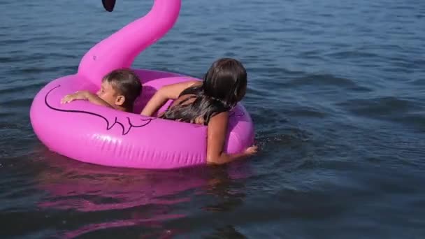 Радостный счастливый мальчик и девочка играют и брызгают вместе в воду — стоковое видео