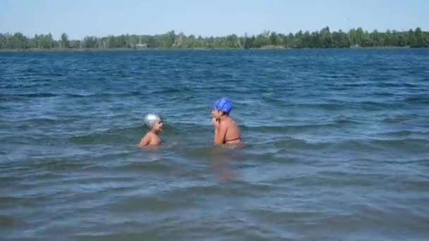 Alegre feliz chico y chica jugar y salpicado juntos en el agua — Vídeos de Stock