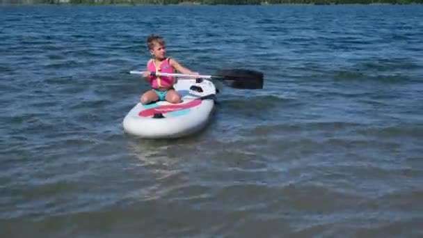 Ufa, Russia, June, 14, 2021, little boy to ride on puddle board — Stock Video