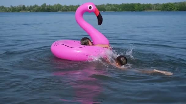 Fröhlich fröhliche Jungen und Mädchen spielen und planschen gemeinsam im Wasser — Stockvideo