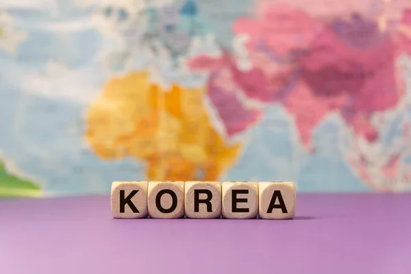 Word Korea Written Wooden Dices Front Purple Background Geographic Map — Stock Photo, Image