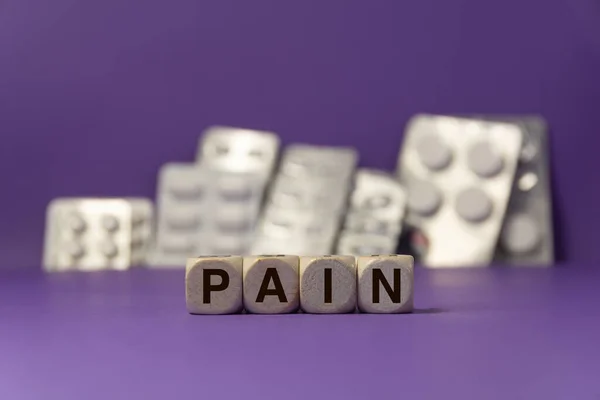 Das Mit Würfeln Geschriebene Wort Schmerz Vor Violettem Hintergrund Mit — Stockfoto