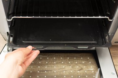 Temiz fırın rafını tutan bir kadın el.