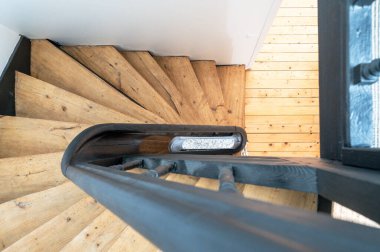 Doğal ışık desenli modern ahşap merdiven. Hafif ahşap basamaklar ve zemin üzerinde dramatik gölgeler oluşturuyor.