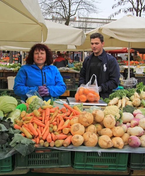 Mujer está vendiendo verduras en el mercado callejero en Liubliana, Eslovenia — Foto de Stock