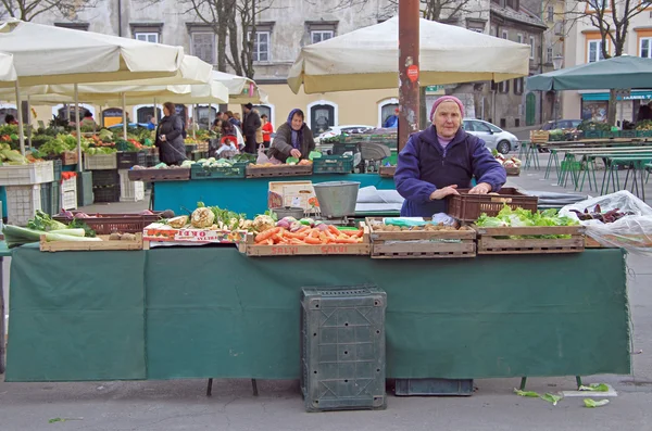 Kobieta sprzedaje warzywa na ulicy rynku w Lublanie, Słowenia — Zdjęcie stockowe