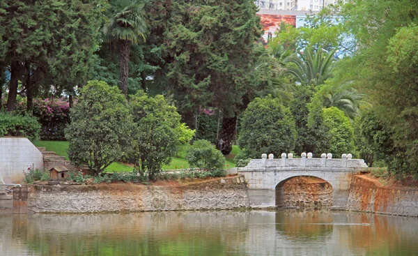 Puente de piedra sobre el estanque en el parque de Kunming — Foto de Stock