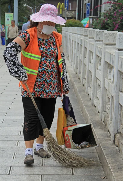 Woman is cleaning up the street in Kunming, China — Stock Photo, Image