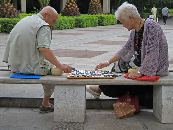 Mann und Frau spielen Go im Park von Kunming, China — Stockfoto