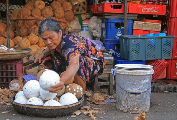 Mujer está pelando cocos en el mercado callejero en Hue, Vietnam — Foto de Stock