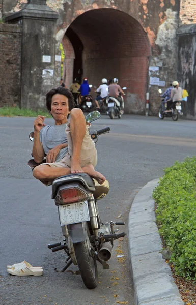 Hombre está sentado en una scooter al aire libre en Hue, Vietnam — Foto de Stock