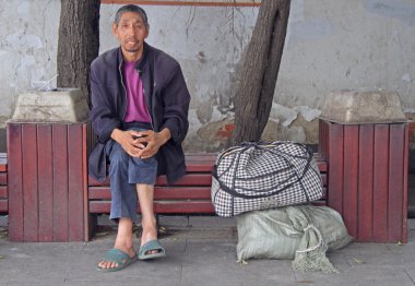 Wuhan, Çin'de açık bir bankta adam dinleniyor