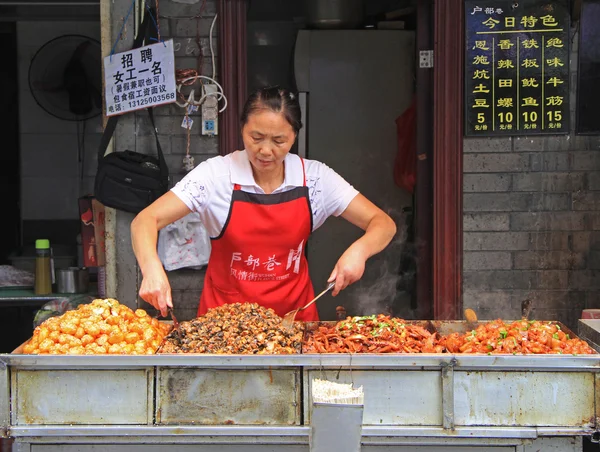 Mujer está vendiendo bocadillos al aire libre en Wuhan, China — Foto de Stock