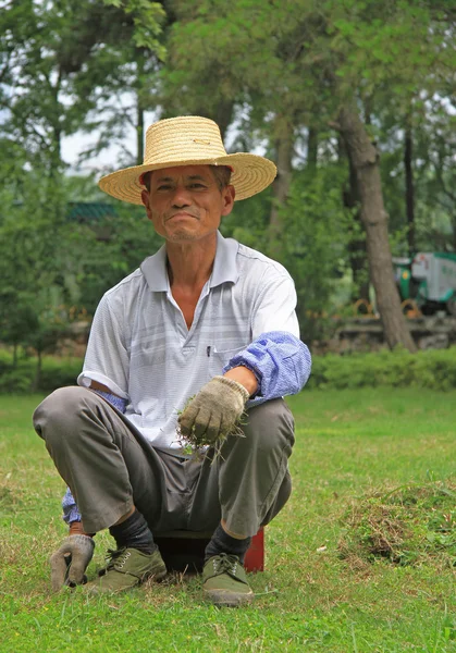 Man is weeding lawn in public garden of Wuhan — Stock Photo, Image