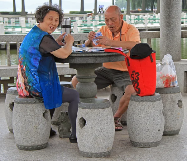 Hombre y mujer están jugando a las cartas al aire libre en Wuhan, China — Foto de Stock