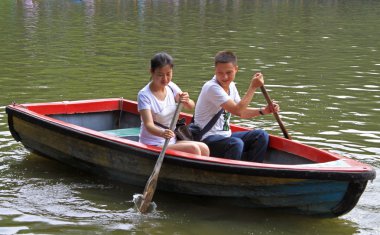 kız ve adam Chengdu parkta göl üzerinde tekne vardır
