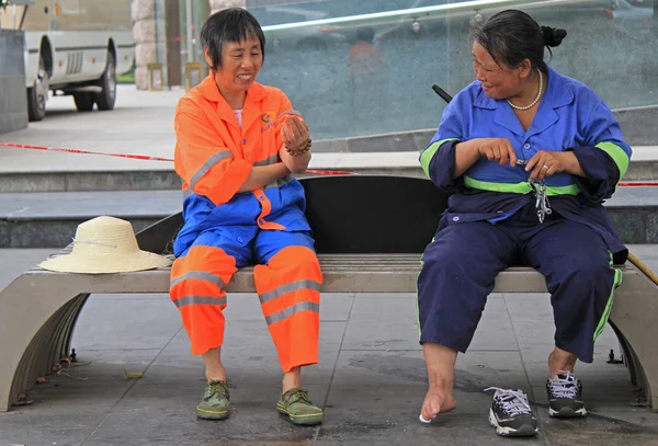 Two service workers are resting on a bench outdoor in Chengdu — Stock Photo, Image