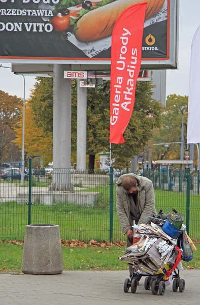 Homem está empurrando carrinho com lixo em Varsóvia, Polônia — Fotografia de Stock