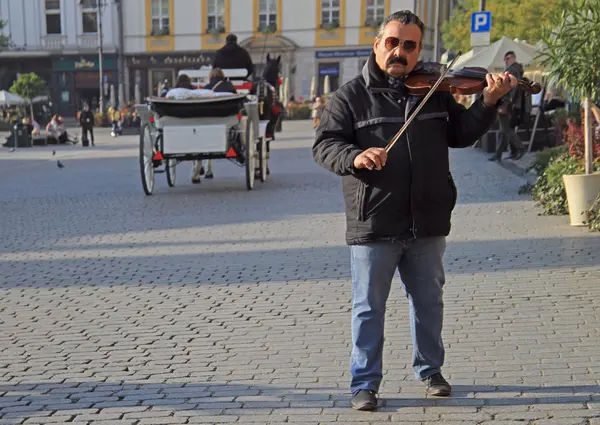 Az ember játszik szabadtéri főtéren Krakkóban, Lengyelországban — Stock Fotó