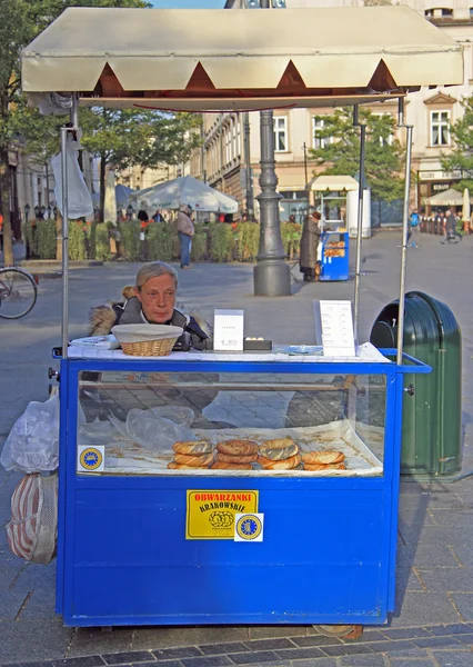 Mujer está vendiendo prezels en la calle de Cracovia, Polonia —  Fotos de Stock