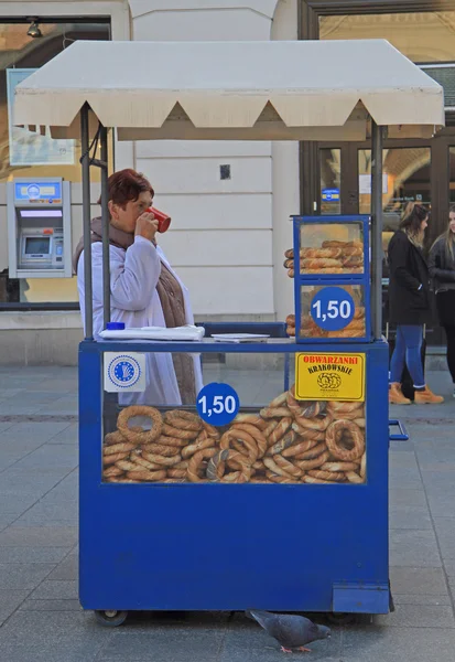 Vrouw is de verkoop van prezels op straat van Krakow, Polen — Stockfoto