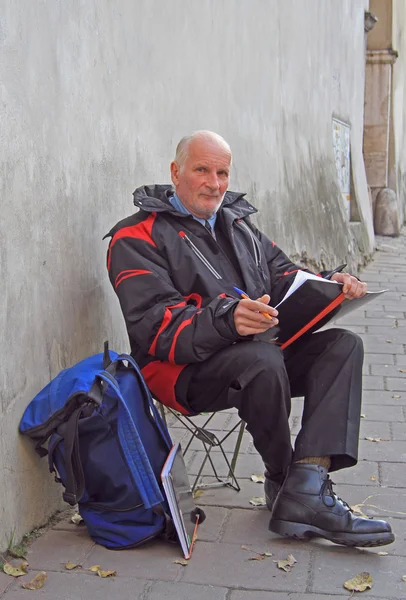 Oude man trekt iets buiten in Krakau, Polen — Stockfoto