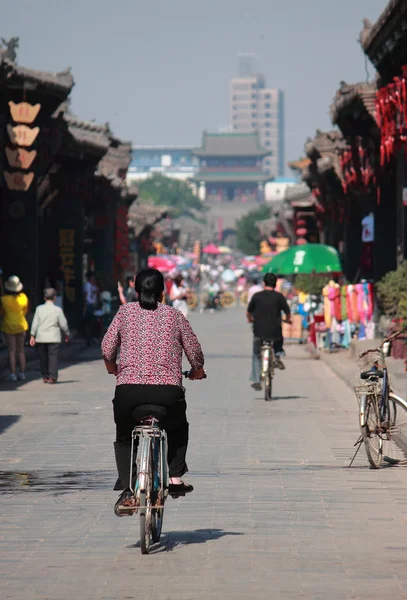 Žena na kole ve starém městě Pingyao — Stock fotografie