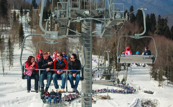 Pessoas deixam objeto esportivo por ropeway com cabines abertas — Fotografia de Stock