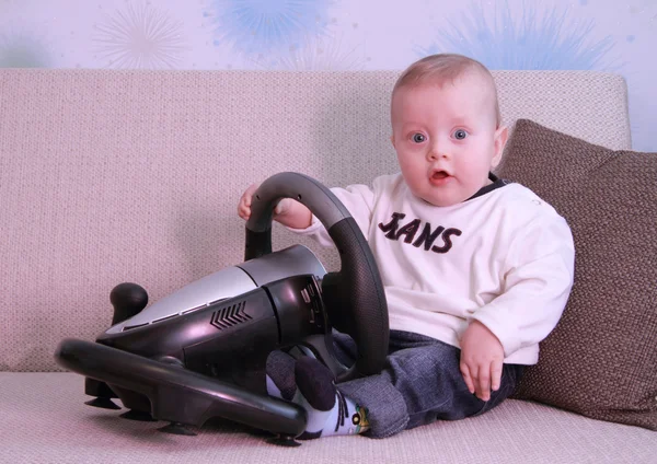 Baby on couch with computer-game device — Stock Photo, Image