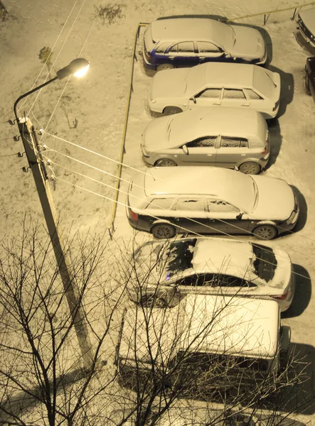 Bilar på parkeringen på innergården på natten, vinter — Stockfoto