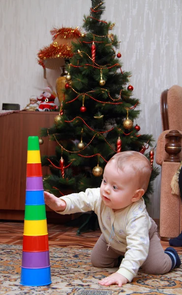 Bebé tratar de tirar de la pirámide de colores — Foto de Stock