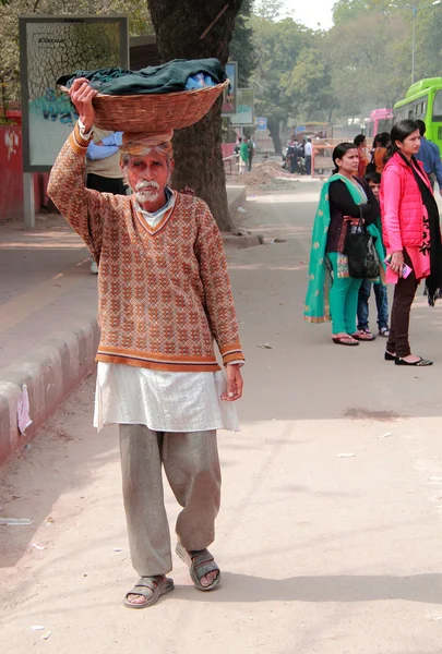 Indian man carries basket with clothes — Stock Photo, Image