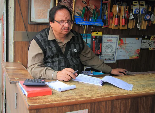 Man on cash desk write something, Delhi — Stock Photo, Image