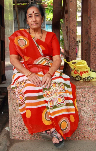 Mujer en el vestido indio tradicional brillante está sentado fuera, Mumbai — Foto de Stock