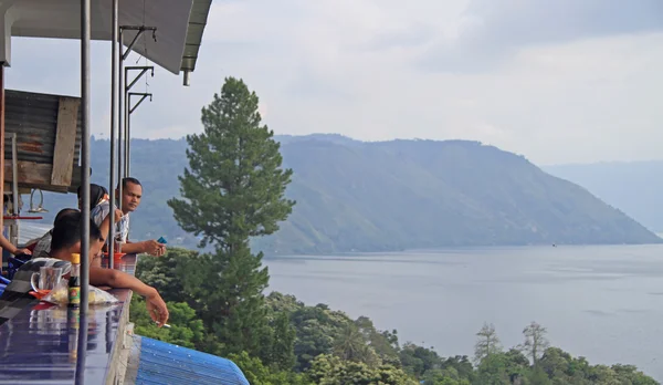 La gente está viendo el lago toba desde la cubierta de conservación pública —  Fotos de Stock